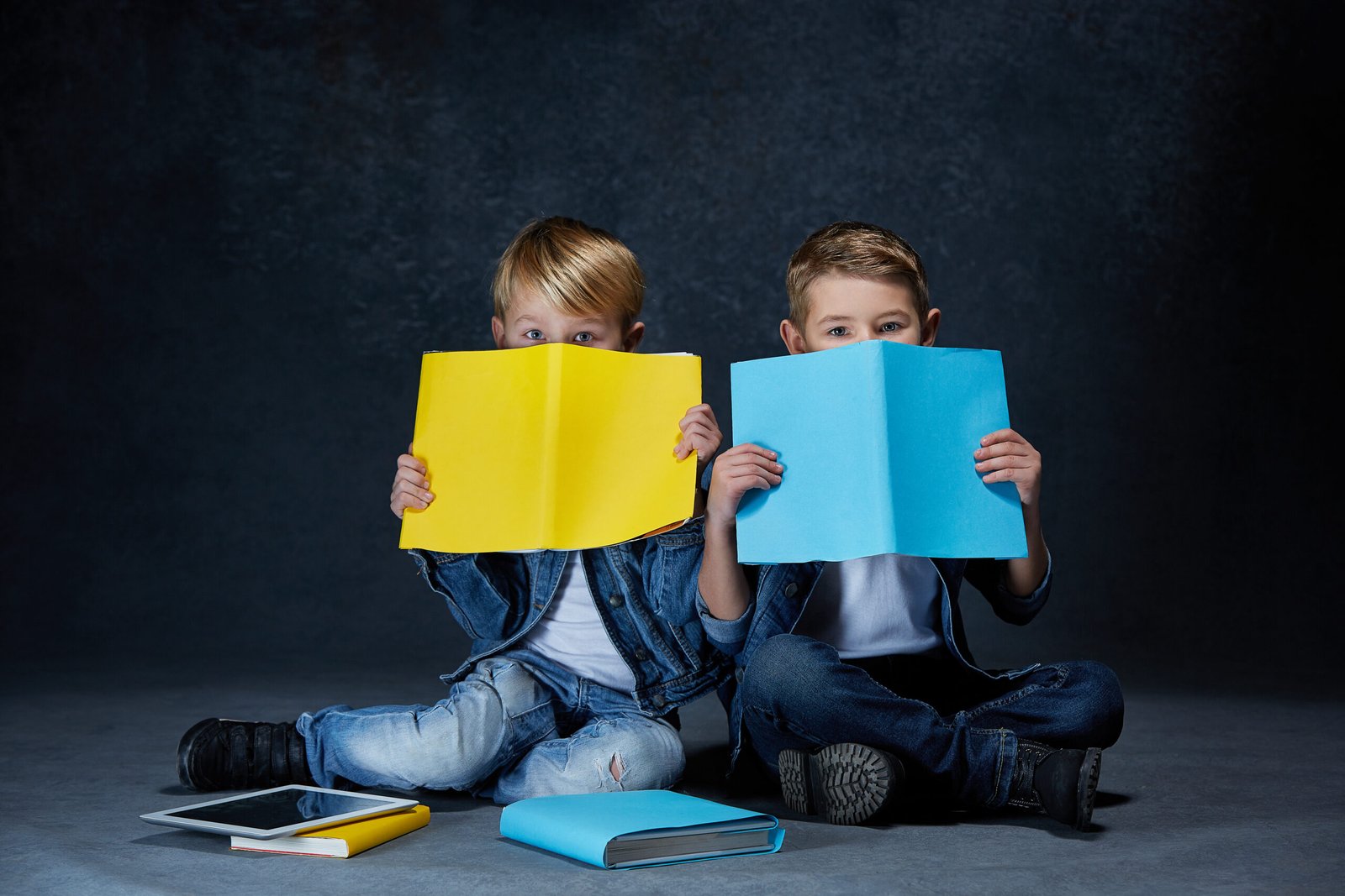 The studio shot of children with books and tablet