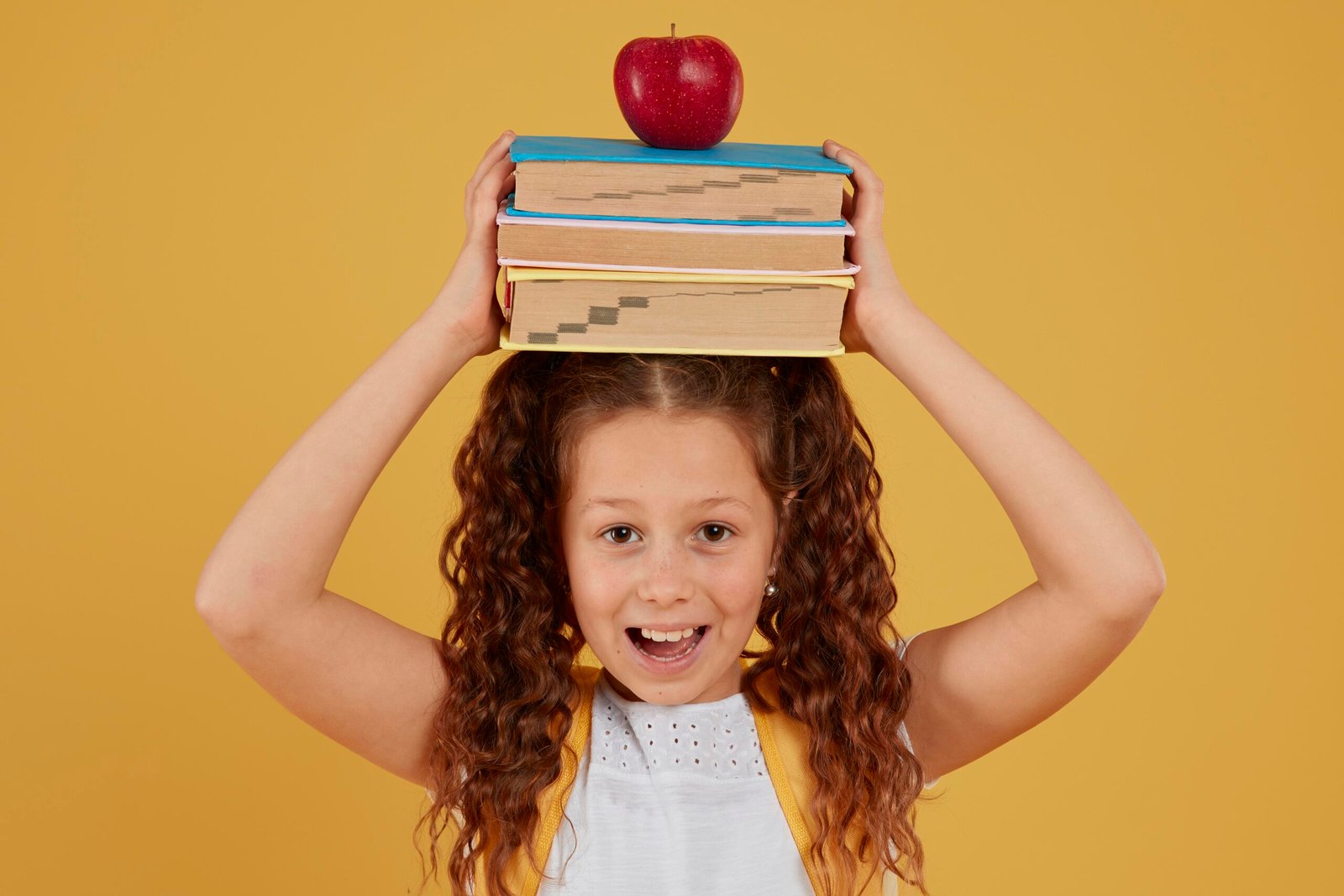 school-girl-holding-books-apple-her-head